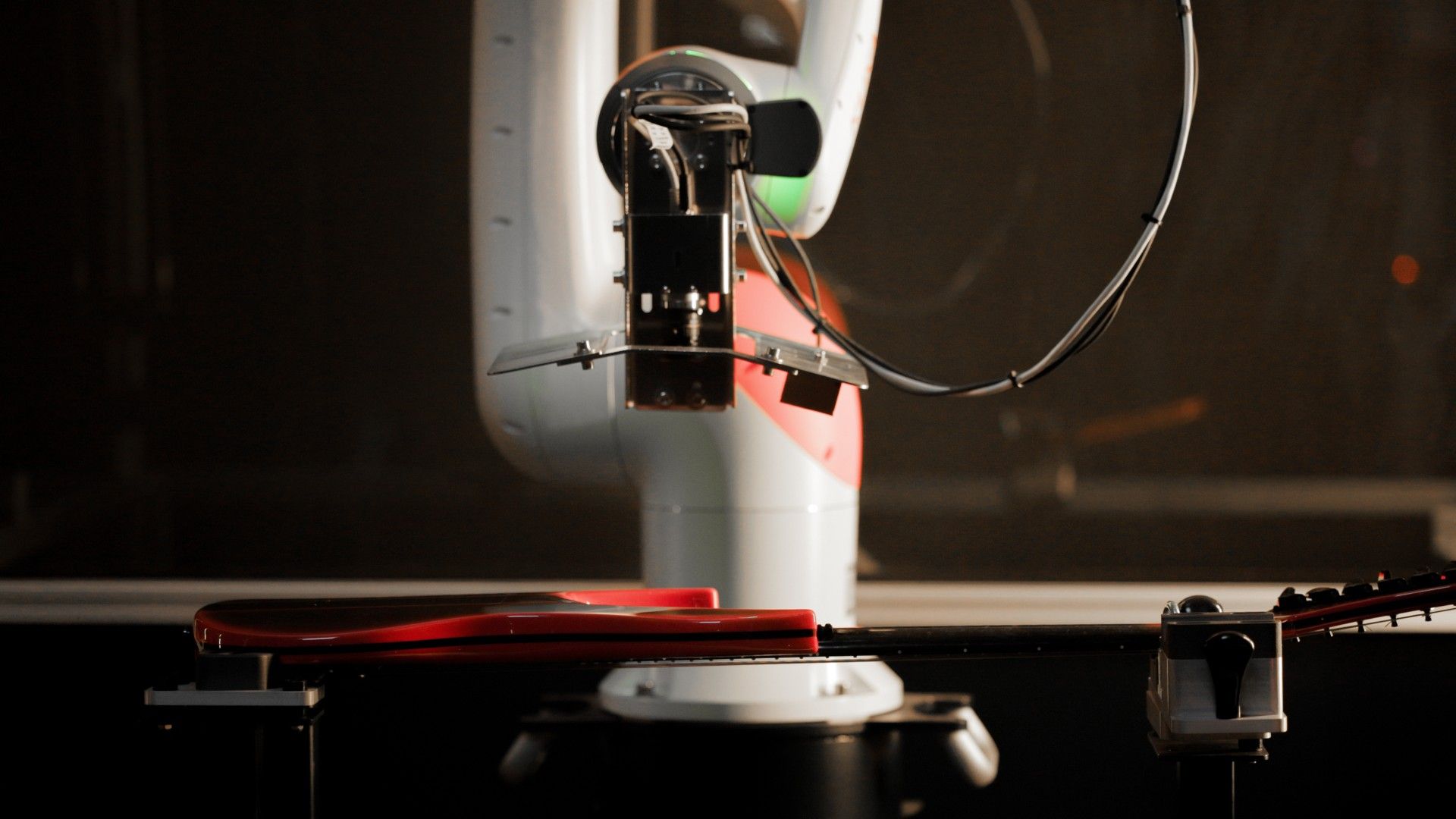 Industrial camera above a red guitar on the inspection rig