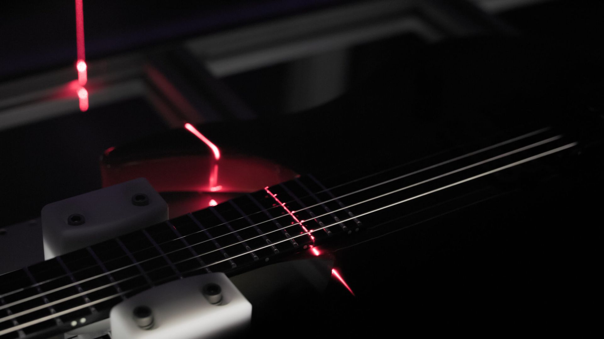 Red laser scanning the guitar strings and fretboard